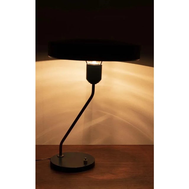 A special desk lamp by louis kalff for philips. The lamp has a dark green, metal, shade and base. The lamp is in a good...