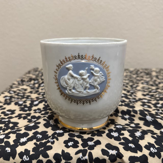 This exquisite vintage porcelain cup (or small planter/jardiniere) features a charming blue jasperware-style medallion in...