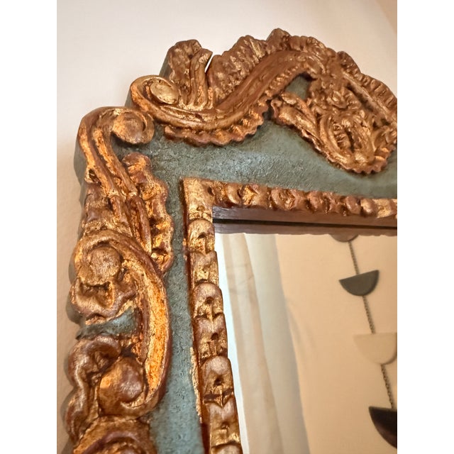 This vintage mirror features an ornate carved wood, hand gilt and painted frame with a gorgeous celadon green accent color...
