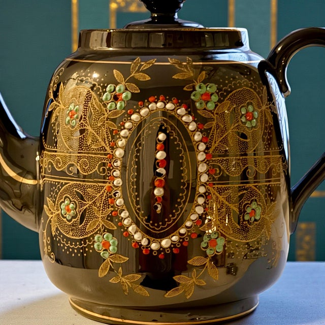 This antique black-glazed teapot was produced by Lingard Webster & Co in Tunstall, Staffordshire, England, and dates to...