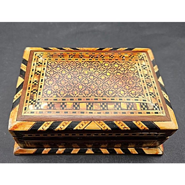 This marvelous vintage 1980s Morocan trinket box is created in gorgeous marquetry wood, inset with mother of pearl. The...