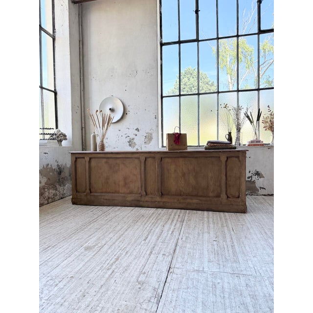Antique 1950s oak trade or shop counter, measuring 2.5 meters in length. it has a striking appearance with its paneled...