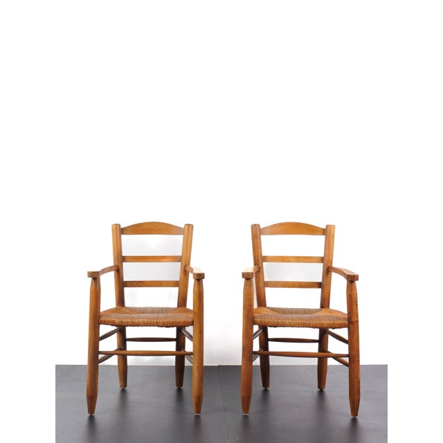 French work in the style of charlotte perriand pair of armchairs france, circa 1960 wood & straw h: 95 cm / w: 55 cm / d:...