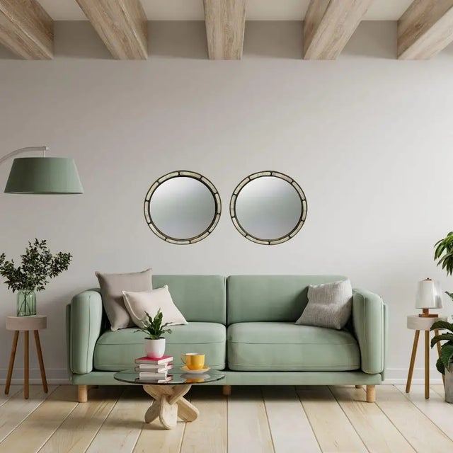 An exquisite pair of Art Deco-style round mirrors exuding timeless sophistication and featuring a harmonious blend of...