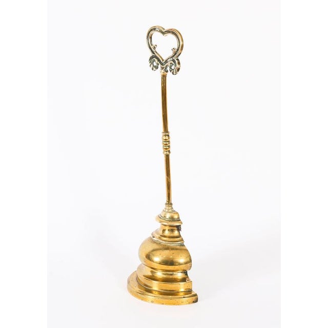 A elegant Victorian brass Brass door stop / door porter stand, circa 1880 in date. The door stop features a loop heart &...