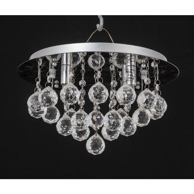 Quoizel Chrome and Raindrop Crystal Chandelier, with four light sockets, circular chrome base, and hanging faceted crystal...