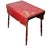 A scarlet surface worn by time, this folding table carries its history in layers of paint. The drop leaves fall...