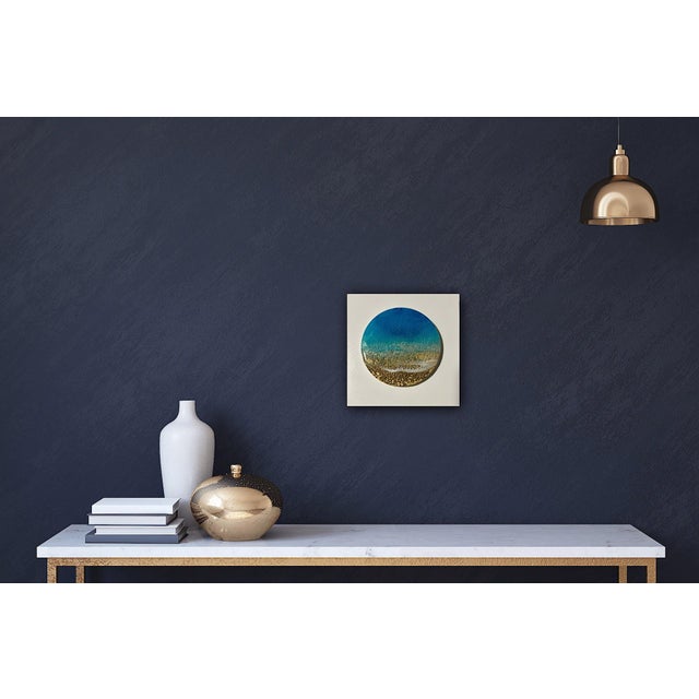 This mixed media piece presents a tranquil seascape, where vibrant turquoise waves seamlessly blend into a sandy shore,...