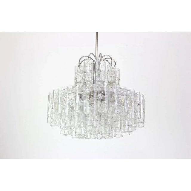 Fantastic four-tier midcentury chandelier by doria, germany manufactured, circa 1960-1969. Murano glass cylinders...
