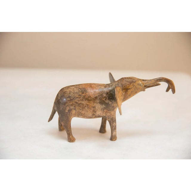 Vintage handmade African light patina elephant trunk up. Circa mid 20th century and possibly older, this piece has such...