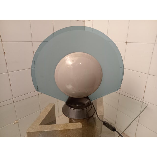Glass, metal, and methacrylate table lamp, designed by Pier Giuseppe Ramella for Arteluce in the 1980s. The lamp has a...