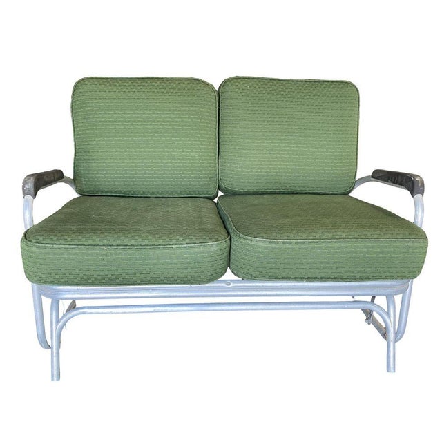 Art Deco patio lounge settee consisting of an aluminum tubular frame with decorative streamlined speed arms. The loveseat...