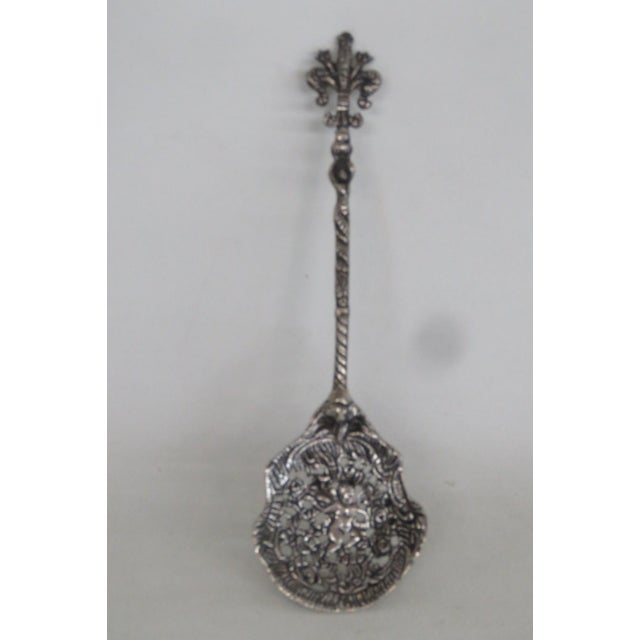 This gorgeously ornate Spoon is made out of silver-toned metal. This stunning statement piece presents an incredibly...