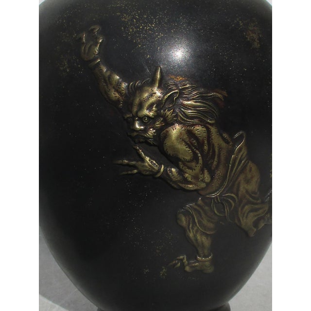 Meiji Globular bronze vase with raised gilt demons running across the visual field and covering the sides with an...