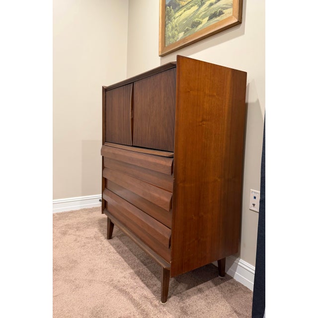 Authentic vintage Lane Furniture tall chest featuring sculpted walnut drawer fronts, fluted cabinet doors, tapered legs,...