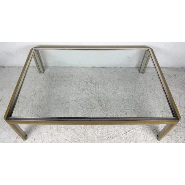 Vintage-modern coffee table featuring rectangular metal base with brass finish and glass top, manufactured in the style of...
