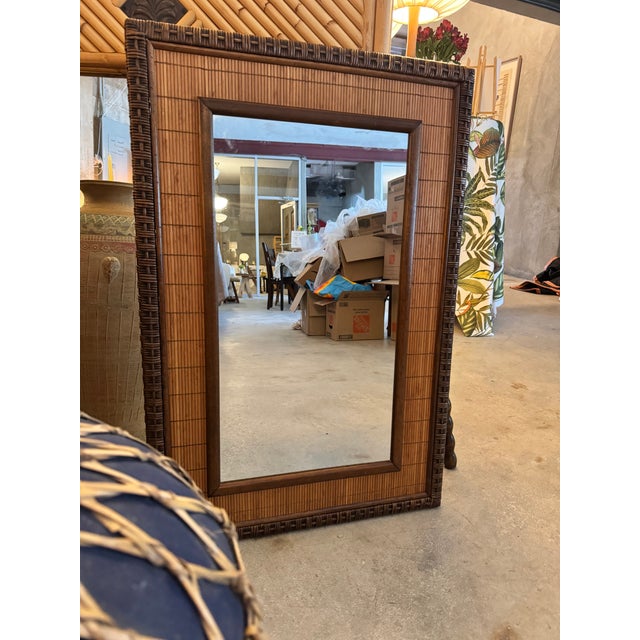 A substantial vintage wall mirror framed in richly toned woven bamboo mat with a clean slatted wood inner border — the...
