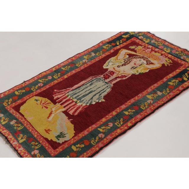 Hand-knotted in wool, this vintage 3x5 Turkish rug dates to circa 1950–1960 and is a rare pictorial piece inspired by...