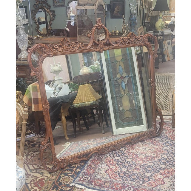 Large carved mahogany 1940 mantel wall mirror. Features highly pierced carved frame featuring shells, scrolls and flowers...