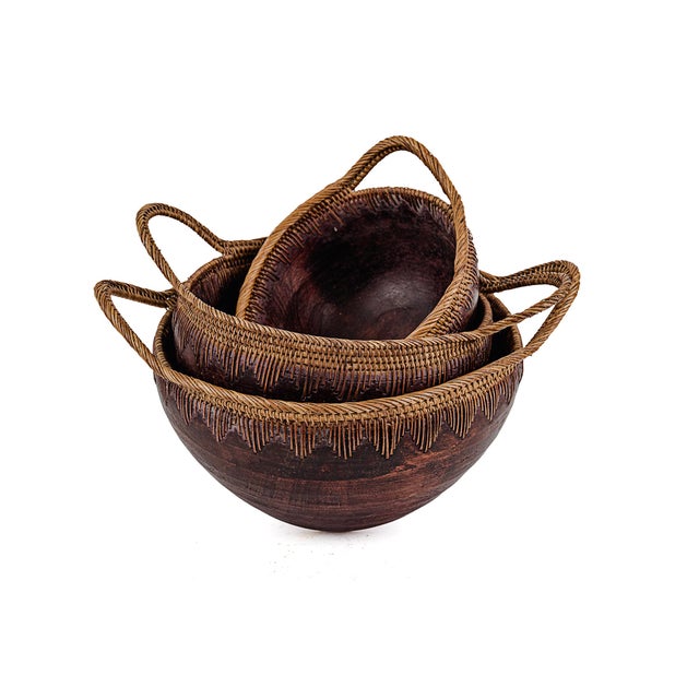 Vintage Indonesian Handmade Nesting Wooden Bowls. Featuring distinctive handwoven rattan handles and rims. Typically...
