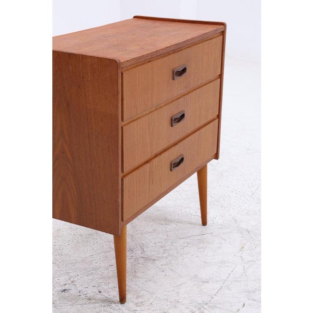 Beautiful vintage teak chest of drawers from the 1960s with a clean, compact form and a calm, even grain. Three drawers...
