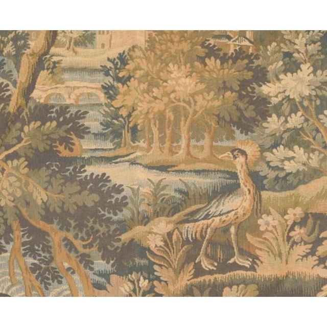 A French verdure tapestry depicting a deep woodland glade in a soft, harmonious palette of sage, moss, ochre and faded...