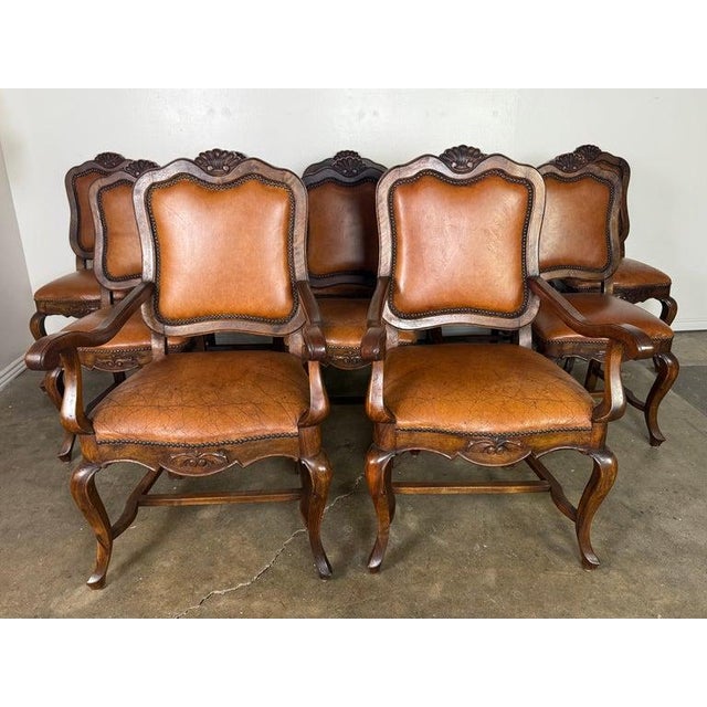 This elegant set of ten dining chairs is crafted in carved wood with classic French-inspired lines and richly patinated...