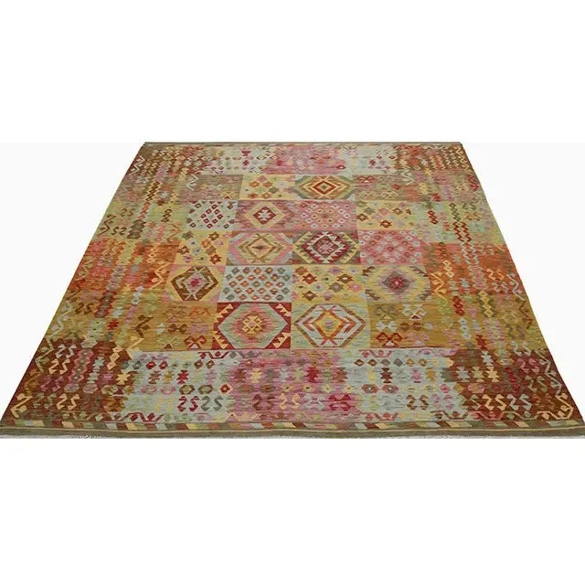 This fun rug is a beautiful traditional handwoven Turkish Kilim rug featuring a tile and diamond shape motif in a multi-...