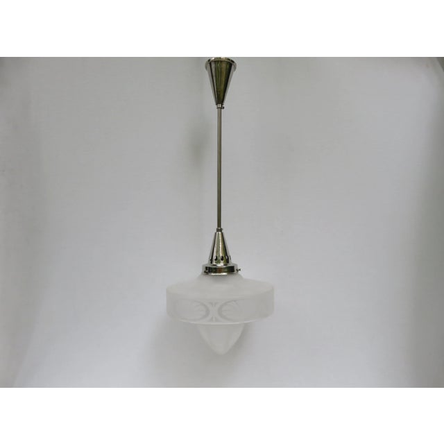 An elegant, reduced form ceiling lamp from the Art Nouveau period with a satin glass lampshade and etched decor. When lit,...