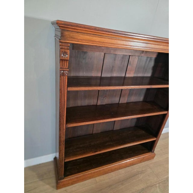 A stunning piece of antique furniture. This bookcase offers ample storage space for books and decorative items. The...