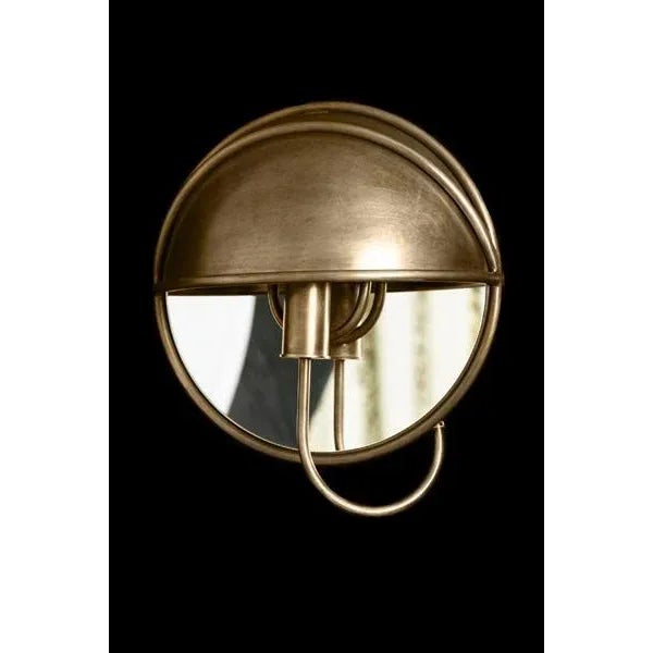 Cast brass sconce with mirror and tubed brass arm arriving into hooded upper section. Moderne style.