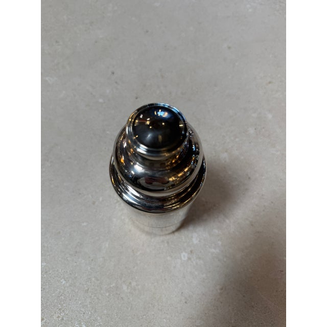 Vintage chrome cocktail shaker by T&F 1905, featuring a sleek three-piece design with built-in strainer and fitted cap....