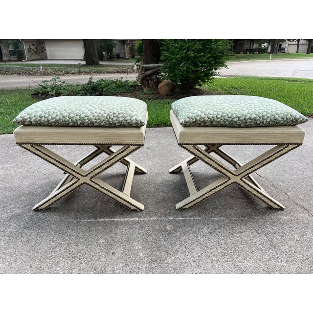Striking pair of Mid-Century X form upholstered benches, circa 1960s - 1970s. These stunning stools are designed with two...