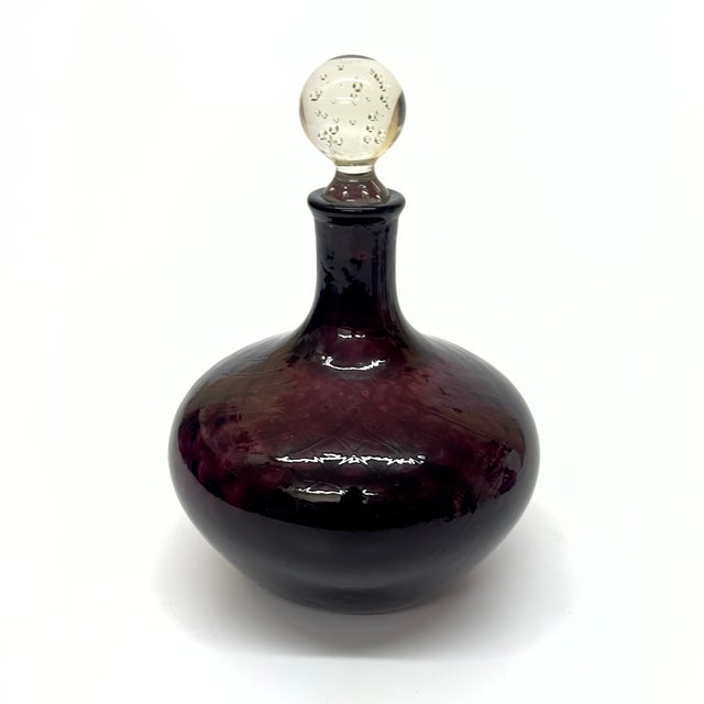 Amethyst lidded decanters, group of 3. A stunning group of mid-20th-century amethyst purple glass lidded decanters in...