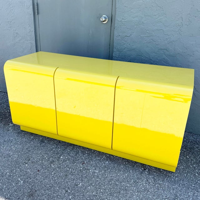 A bold and sculptural Postmodern waterfall dresser, finished in an electrifying high-gloss yellow laminate that instantly...