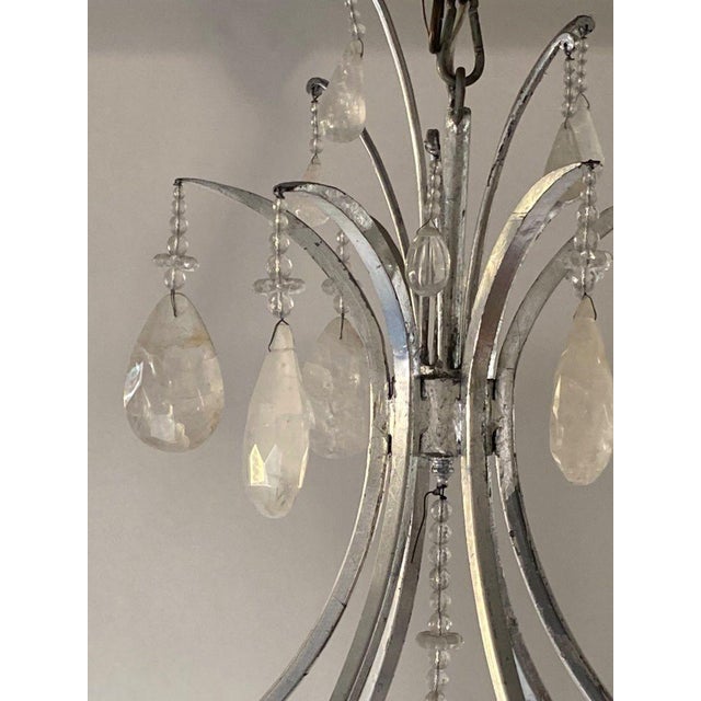 A dramatic large-scale American chandelier from the 20th century, finely constructed in silver-leaf wrought iron and...