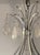 A dramatic large-scale American chandelier from the 20th century, finely constructed in silver-leaf wrought iron and...