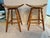 These 2 are Amish handcrafted swivel saddle bar stools featuring a light brown wood base and upholstered leather seats...
