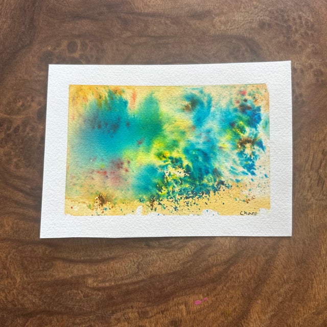 An uplifting splash of blues, aquas, and sandy yellows reminiscent of ocean waves meeting the shore. Bright and breezy,...