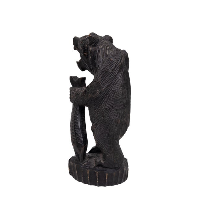 Famously from Hokkaido and northern Japan, this large, intricately hand-carved bear statue with a fish in its maw is a...
