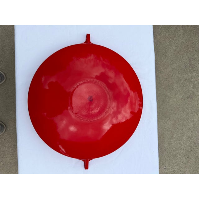 A vintage enamelware paella pan by Dansk, featuring the brand's signature Scandinavian modernist design with red handles....