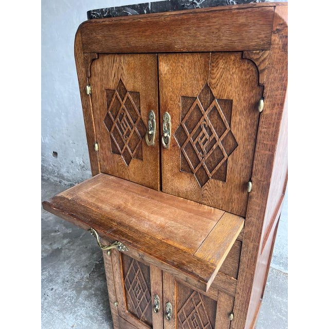 A distinctive french art deco cabinet dating from around 1930, crafted in richly grained oak and topped with a dark,...