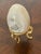 Easter egg on gold tone stand , carved and polished gray agate stone .