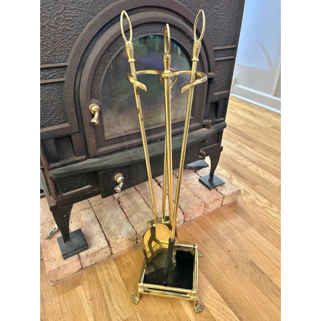 This brass set of fireplace tools and stand come from a 1970’s estate but look unused. The set is in the colonial revival...