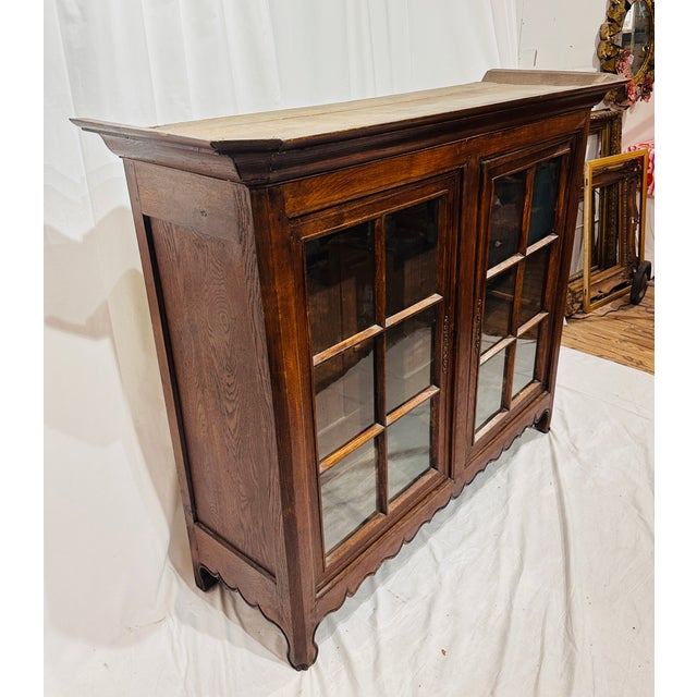 Antique English solid oak glass door bookcase cabinet featuring two glazed cabinet doors, six-light windowpane muntins,...