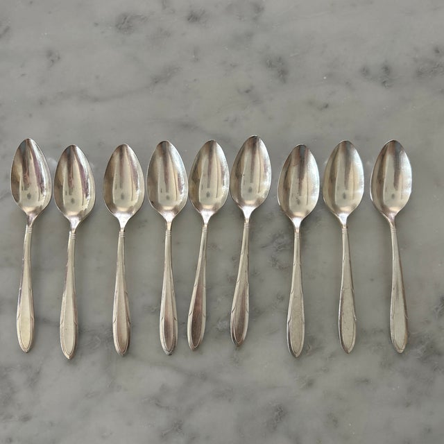 Assorted 24-piece collection of vintage silver-plated flatware by Nobility Plate. The utensils feature an elegant,...