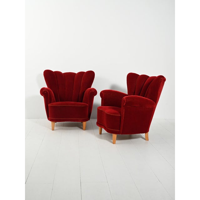 Pair of 1940s Swedish armchairs in red velvet, with shell-shaped backs and oak legs. Pair of vintage 1940s Swedish...