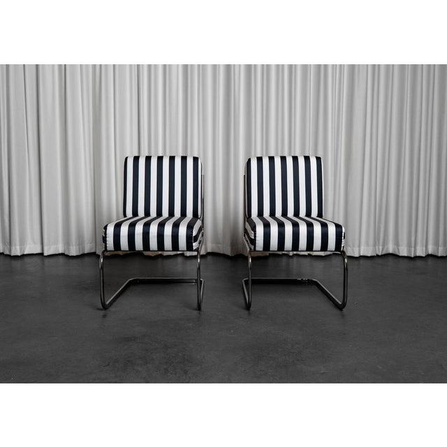 Pair of Seventies-style lounge chairs, fully reupholstered in a striped satin fabric. These chairs are in very good...