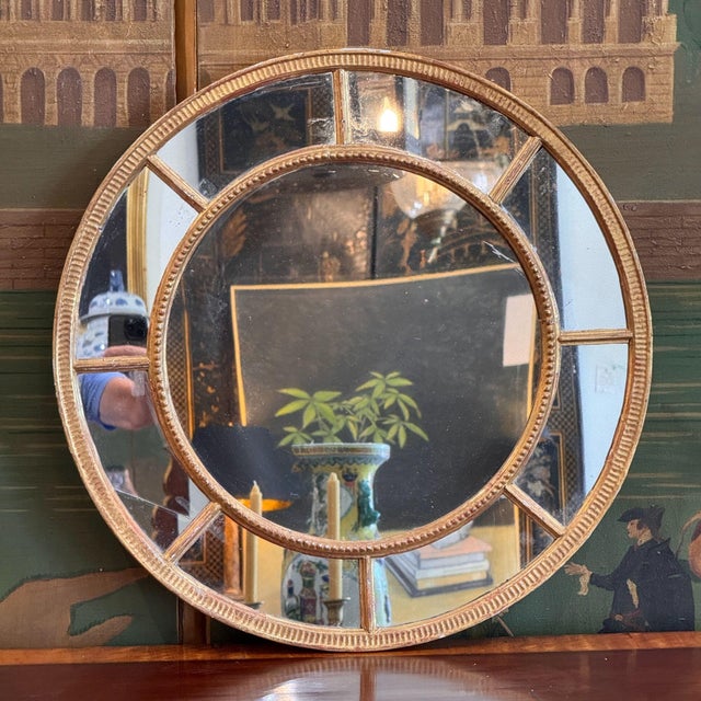 An 18th century George III giltwood circular mirror, the round center plate set within a beaded frame and ringed by a...