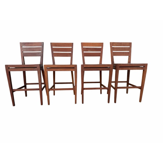 Elevate your outdoor entertaining space with this exceptional, matching set of four vintage solid teak barstools by the...